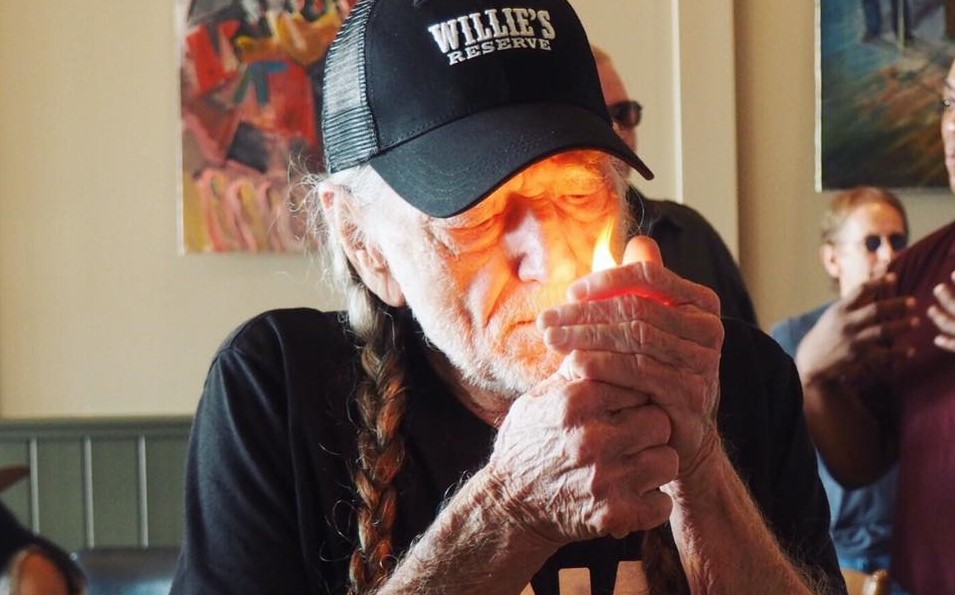 Willie Nelson lighting up a joint